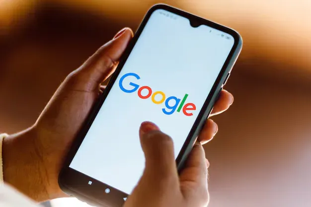 Pessoa segurando um celular com a busca do Google aberta, pesquisando um serviço em Joinville